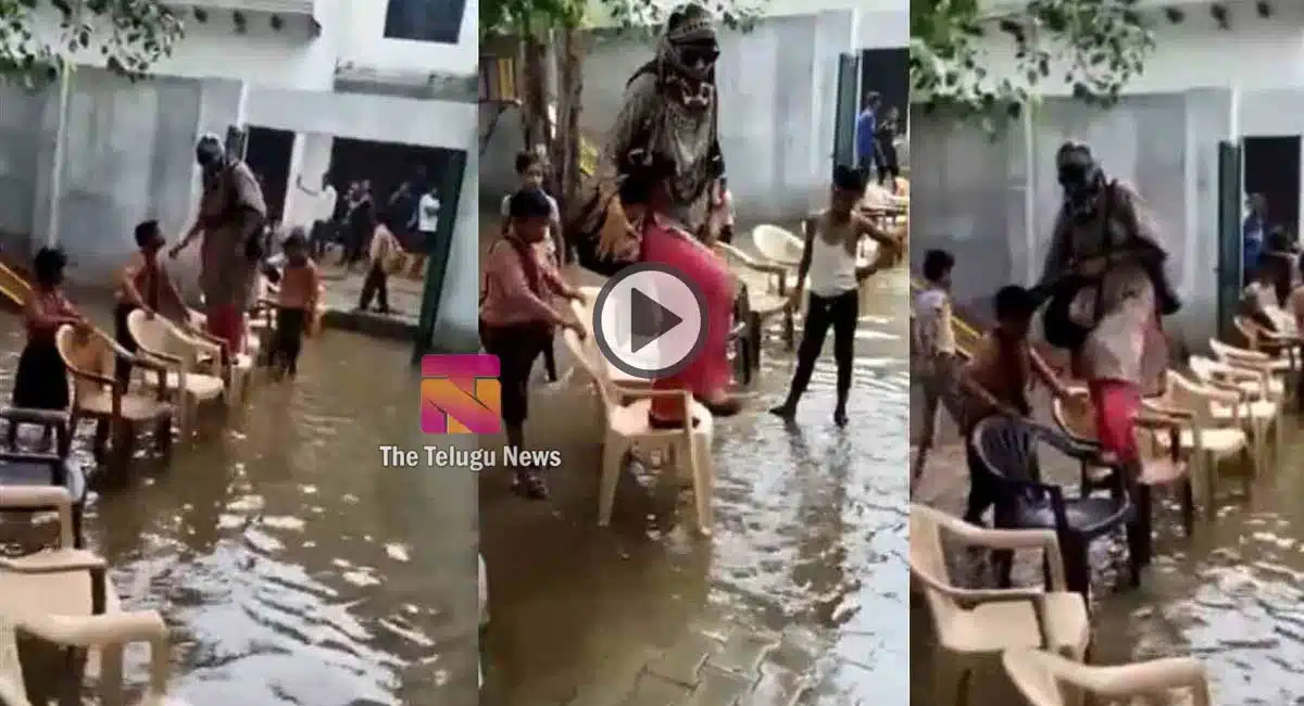 Teacher crossing the flood water with students on chairs
